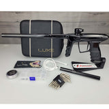 USED DLX Luxe IDOL Paintball Marker Black Polished with case and accessories on a woodgrain background