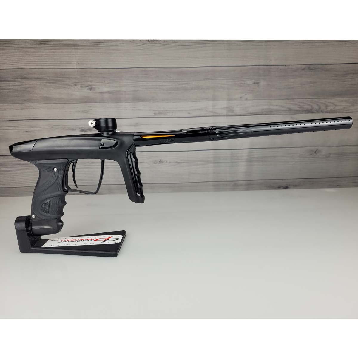 Right side USED DLX Luxe TM40 Paintball Marker Black against a woodgrain background
