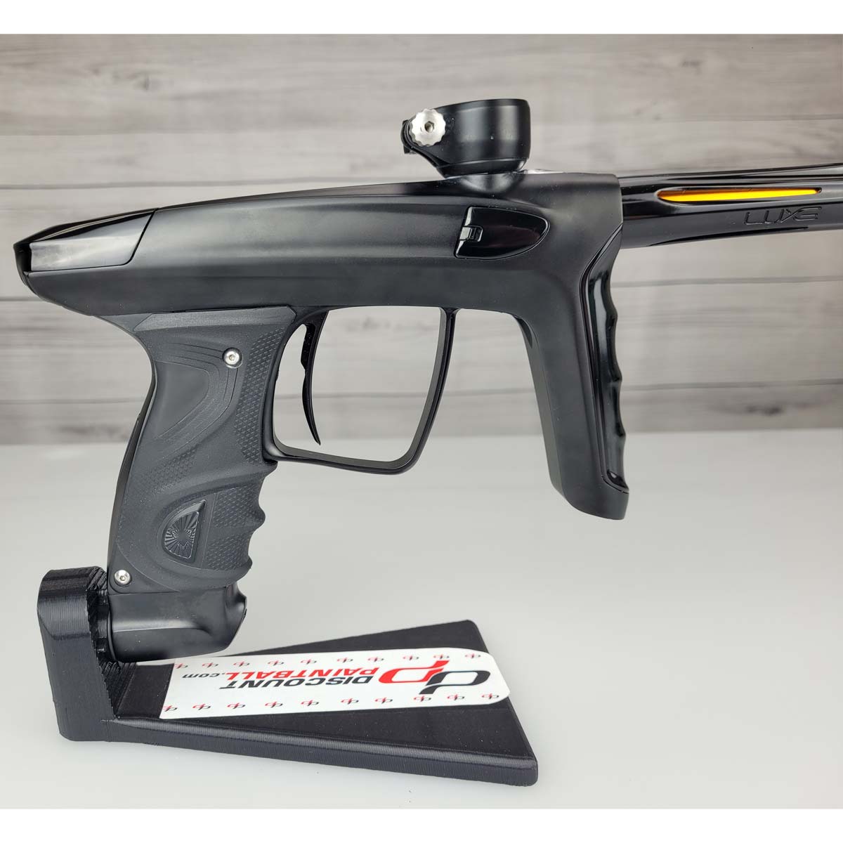 right side body close up USED DLX Luxe TM40 Paintball Marker Black against a woodgrain background