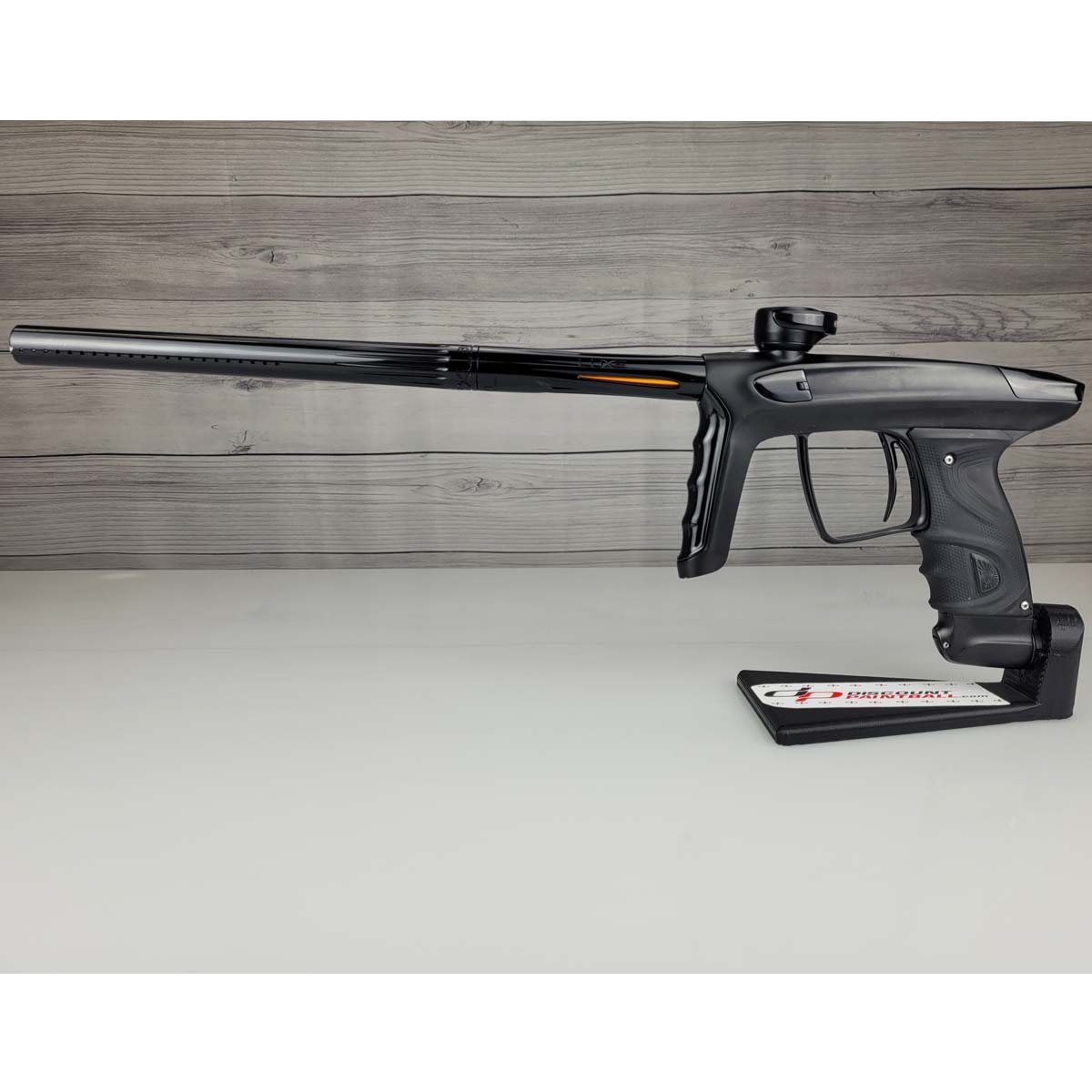 Left side USED DLX Luxe TM40 Paintball Marker Black against a woodgrain background