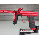 Left side body USED DLX Luxe Aire Red Polished paintball marker on a stand against a woodgrain background