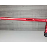 Left side barrel USED DLX Luxe Aire Red Polished paintball marker on a stand against a woodgrain background
