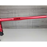 Right side barrel USED DLX Luxe Aire Red Polished paintball marker on a stand against a woodgrain background