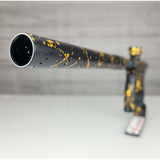 Barrel tip close up USED HK Army Shocker AMP Prestige Black Gold Splash on a woodgrain background