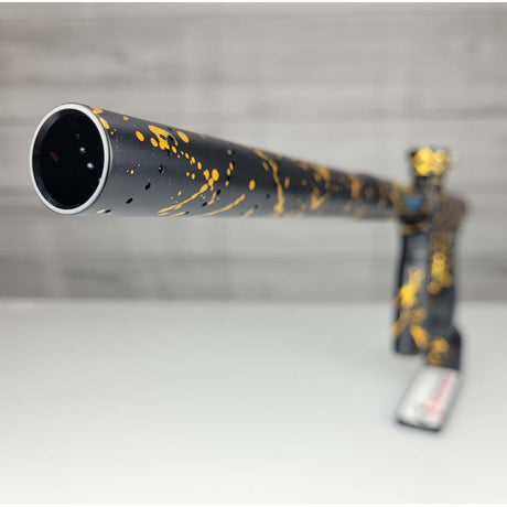 Barrel tip close up USED HK Army Shocker AMP Prestige Black Gold Splash on a woodgrain background
