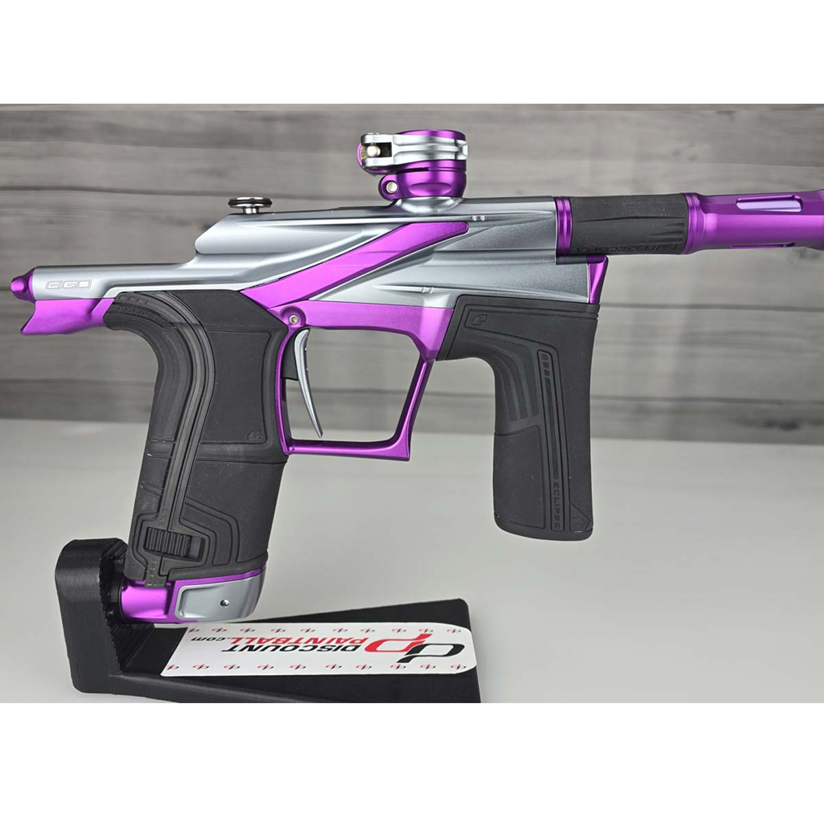 Close up of right side body Purple and silver USED Planet Eclipse LV2 Paintball Marker Havoc Grey Purple on a white surface with a wooden background