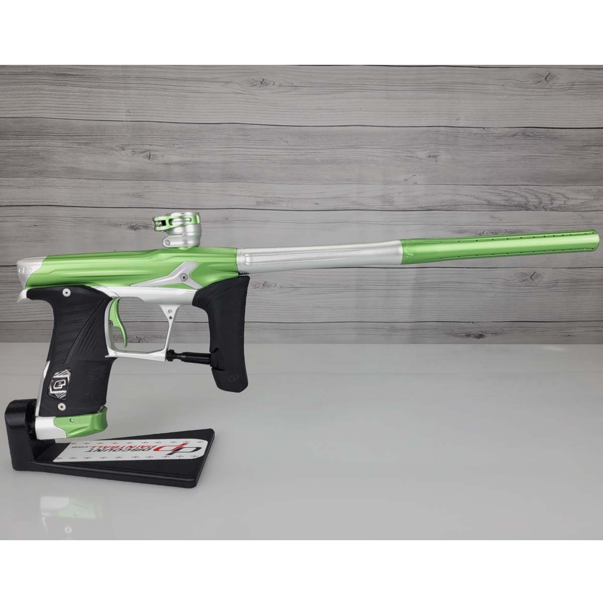 Right side Green and silver USED Planet Eclipse Geo 3.5 Kyrpton Ice Green Silver paintball marker on a wood panel background.