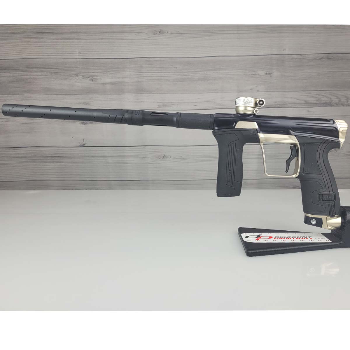 Left side USED Planet Eclipse CS2 Paintball Marker Black Sandstone on a white surface and wooden background
