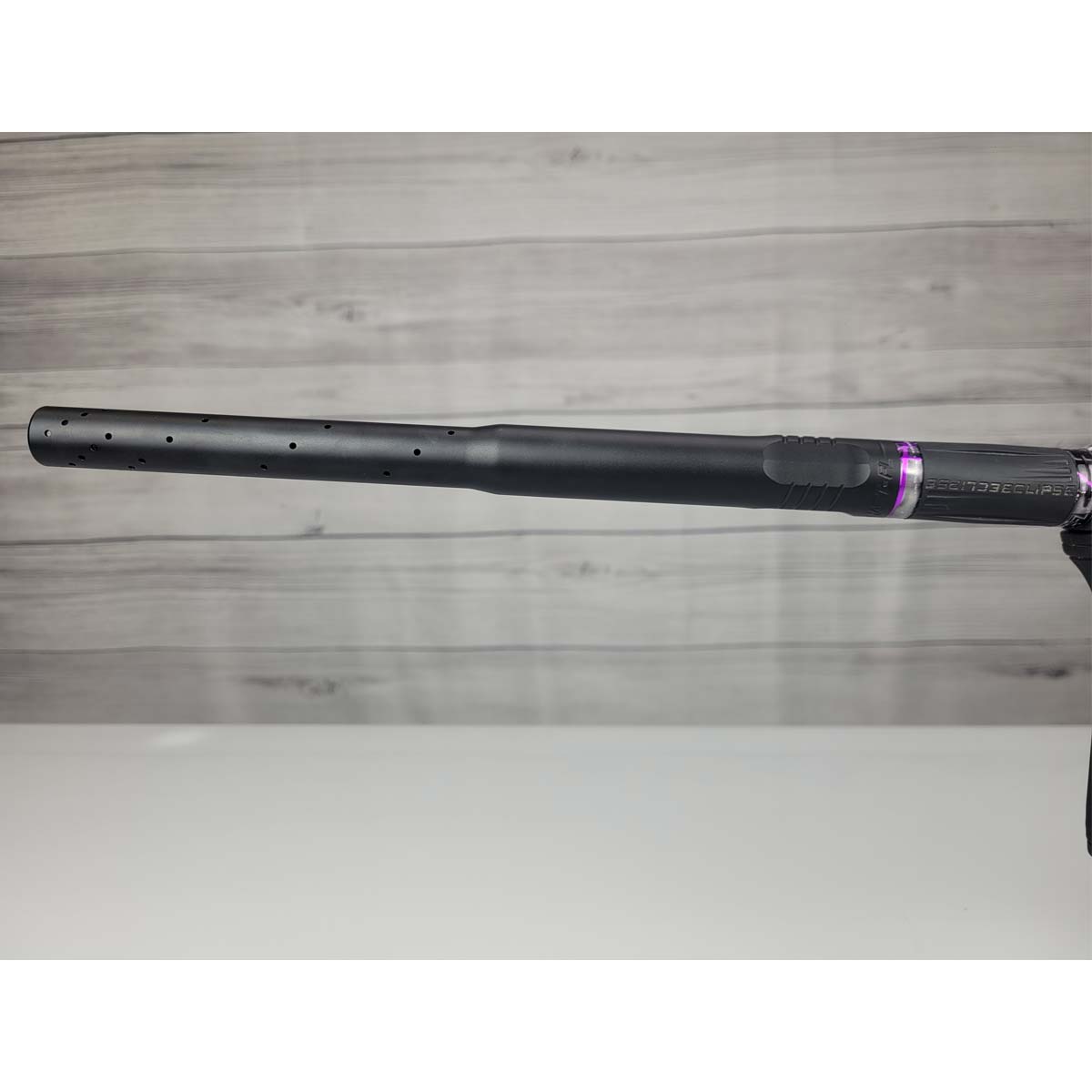 Left side barrel USED Planet Eclipse CS2 Paintball Marker Black Purple Grey Splash on a woodgrain background