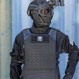 Person wearing a black HK Army BSX Skull Plate Carrier for molle attachments for airsoft and paintball, shown on a blue background