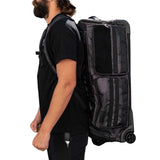 Person wearing a HK Army Expand 75L Roller Gear Bag Shroud Blackout as a backpack against a white background