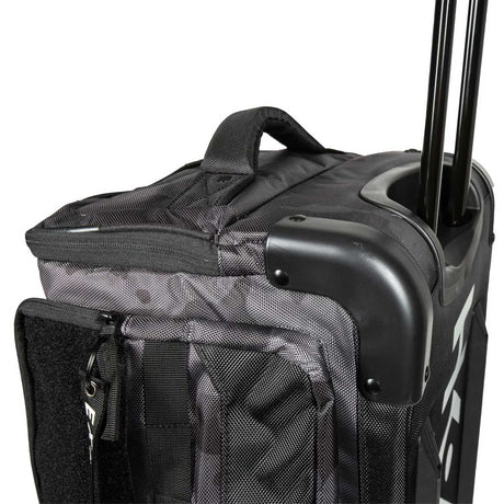 Close-up of a black and gray patterned Back of a black and grey camo HK Army Expand 75L Roller Gear Bag Shroud Blackout against a white background with a telescoping handle extended, showing the top zipper, handle, corner protector, and front zip pocket against a white background.
