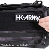 Close-up of a black tactical-style bag with a Velcro patch area and the embroidered text 'HK ARMY' on the front. A hand is touching the patch, and a note at the bottom says '*Patch shown not included'.