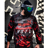 Red, black, white and grey HK Army HSTL Lava long sleeve Jersey on a person dressed for paintball on a busy background