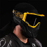 Side angle of person wearing HK Army RMX Thermal Paintball Goggles Black yellow Gold with smoke lens on a black background
