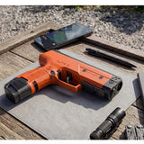 Byrna CL-XL orange left side view with 7 round magazine and 12 gram co2 on a wood table