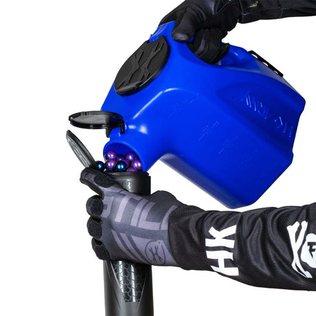 Blue plastic HK Army Reload Paintball Hauler Caddy for loading paintballs into pods and hoppers being used to fill a pod.