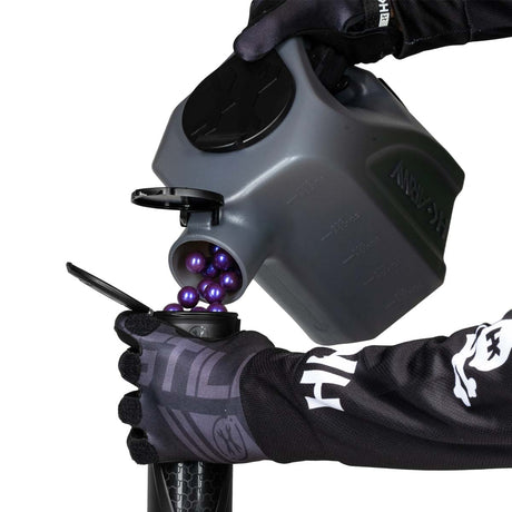 Dark Smoke black plastic HK Army Reload Paintball Hauler Caddy shown loading paintballs into a pod.