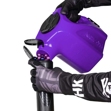 Purple  plastic HK Army Reload Paintball Hauler Caddy loading paintballs into a pod.